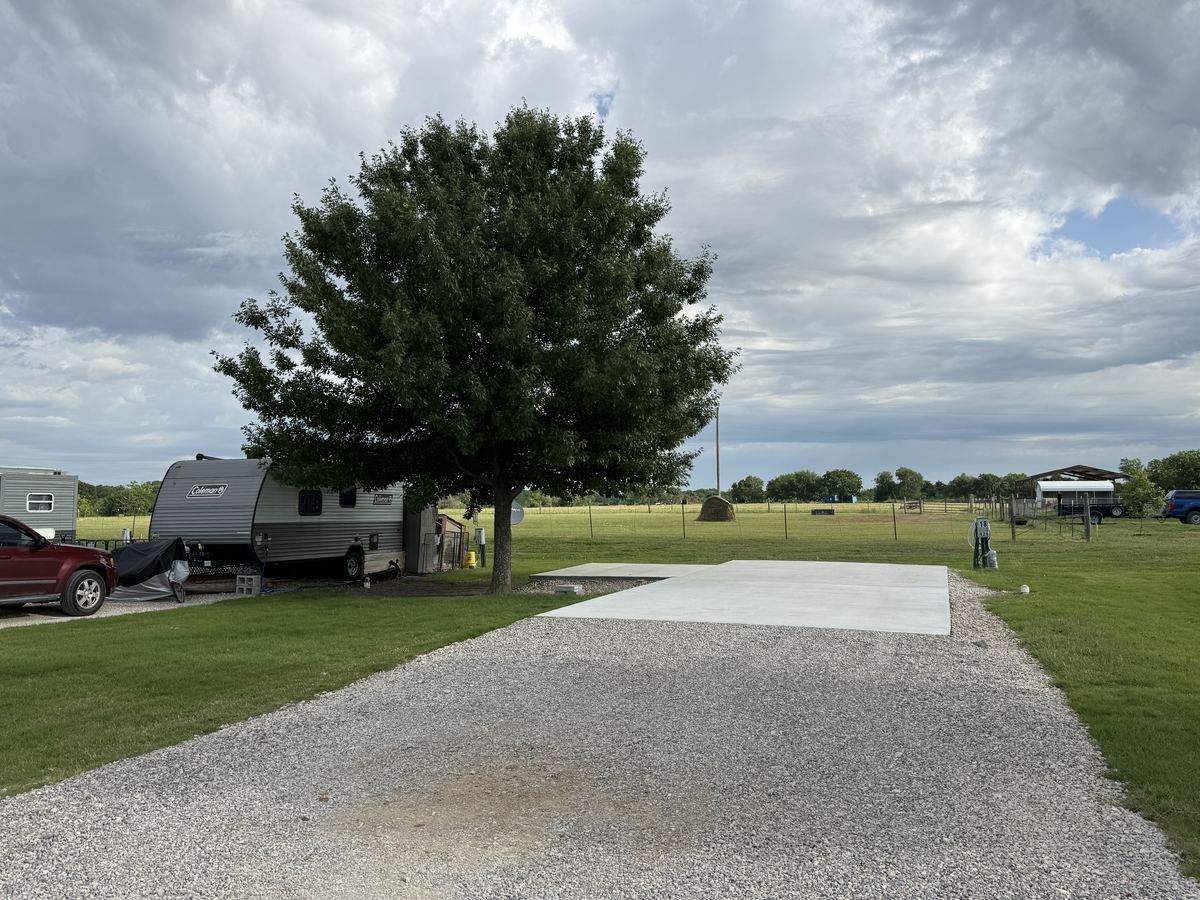 Concrete pad site with patio extension and shade tree