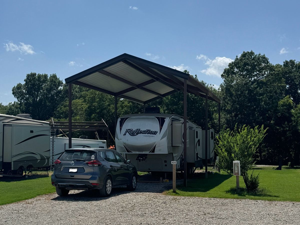 Fifth wheel parked under a covered site canopy