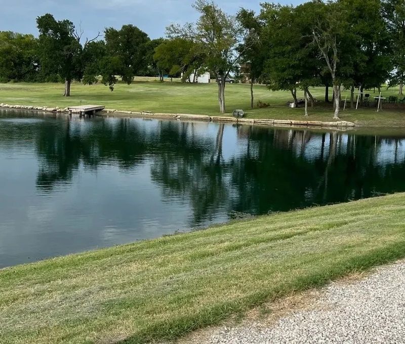 Private stocked fishing pond with dock and stone shoreline